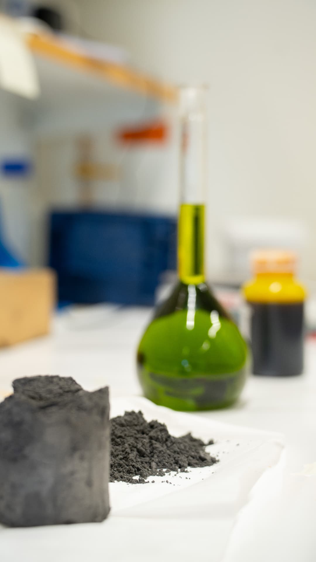 Lab bench with grinding sludge sample, briquette and iron chloride solution